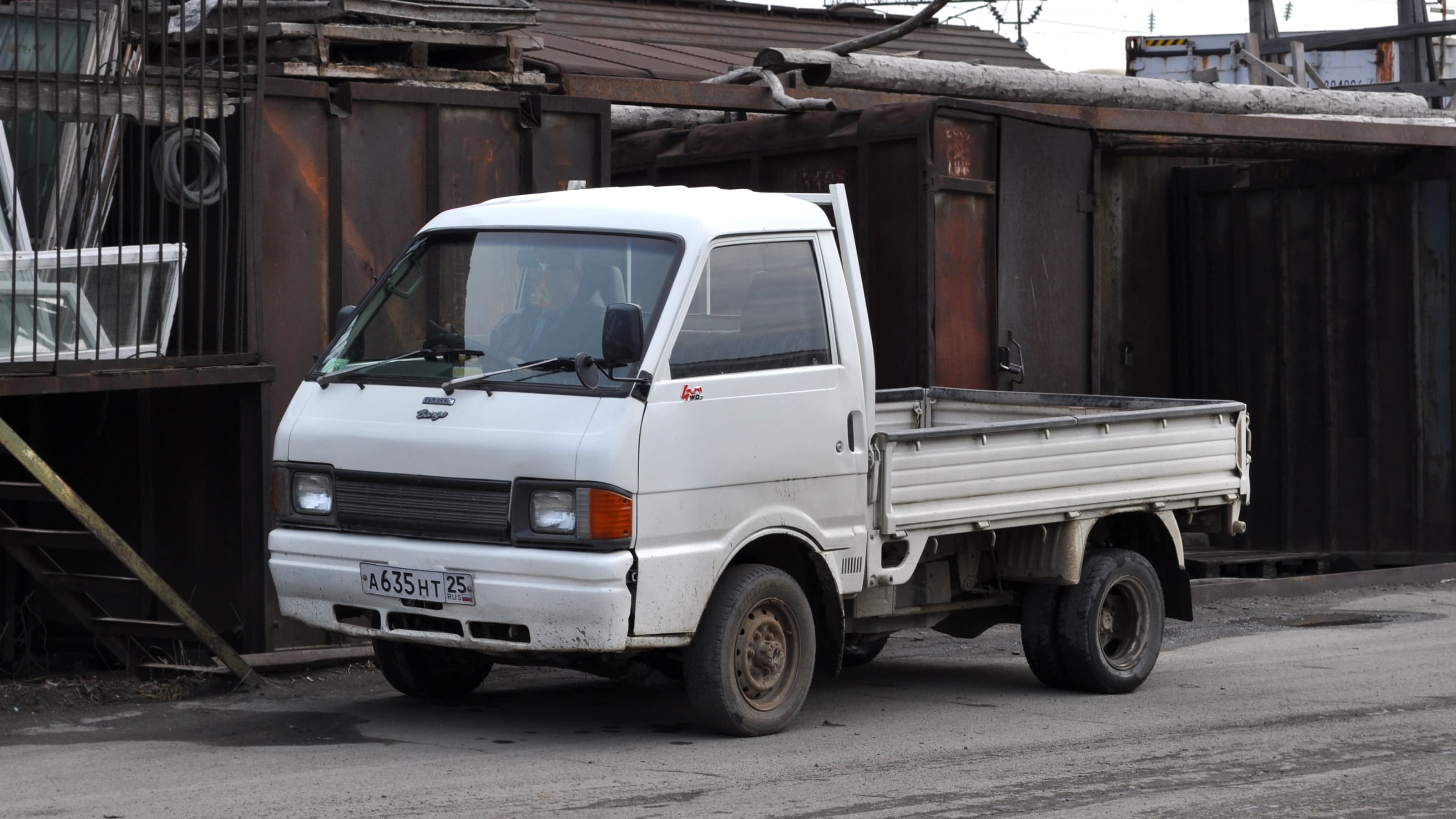 White kei truck driving on a road